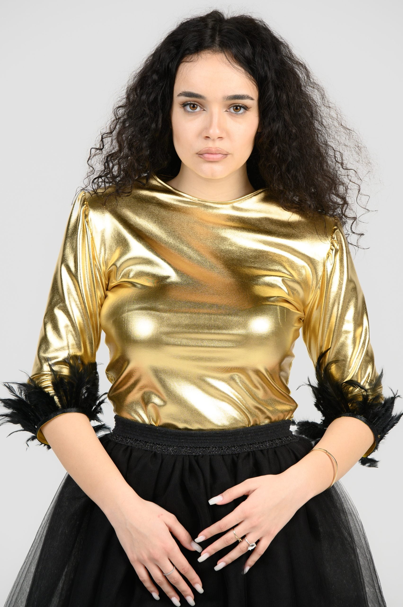 Gold foil bodysuit, with 3/4 sleeves and black feathers on them.