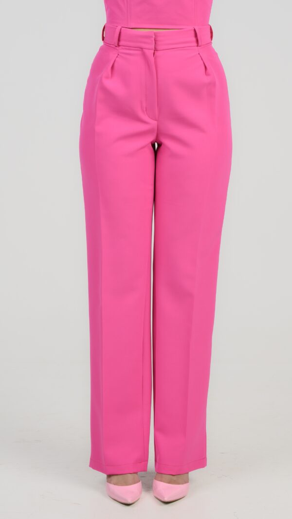 A woman wearing Imperious Trousers, in fuchsia.