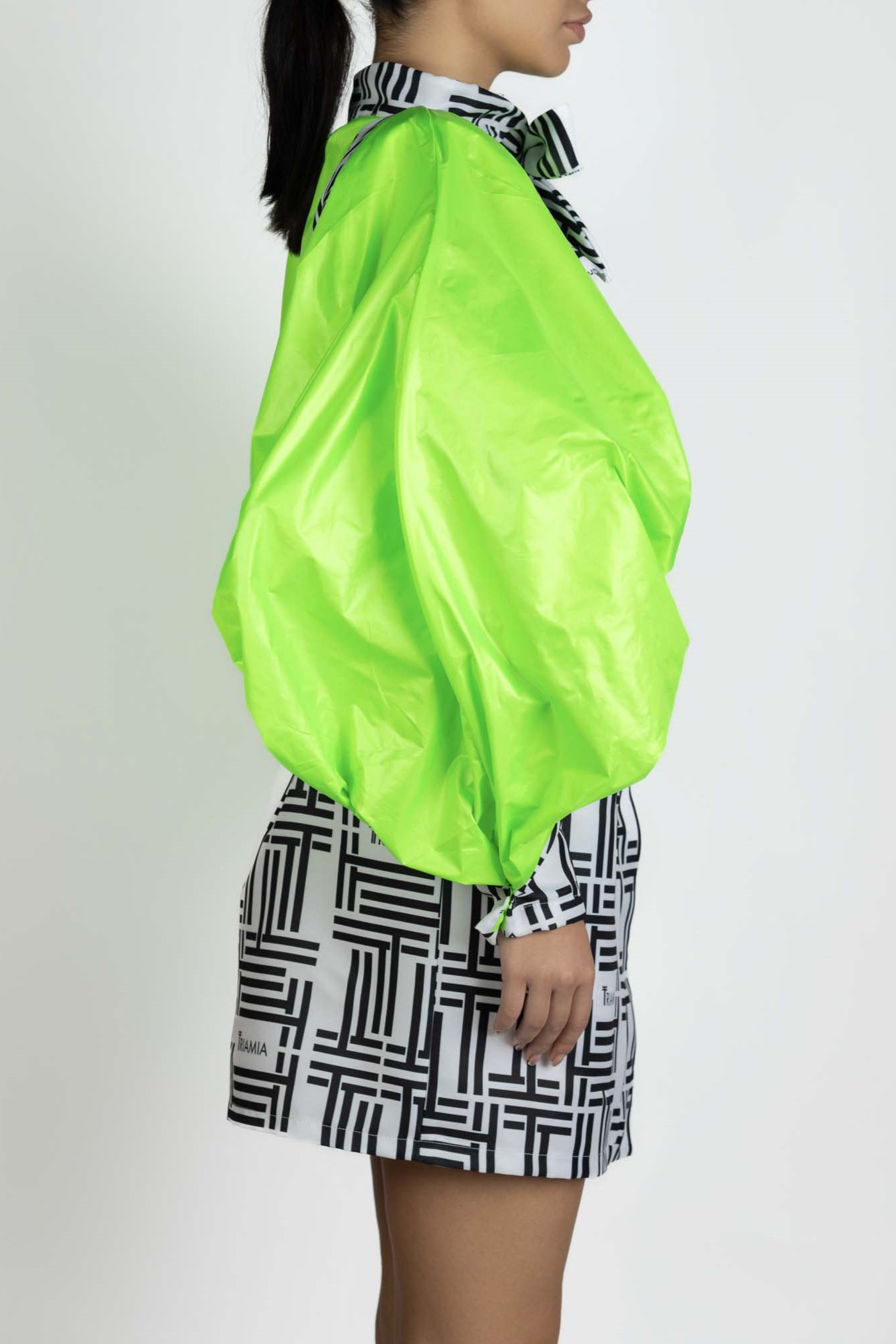 Trench Coat with Triamia Print and neon green details. Side Photo.