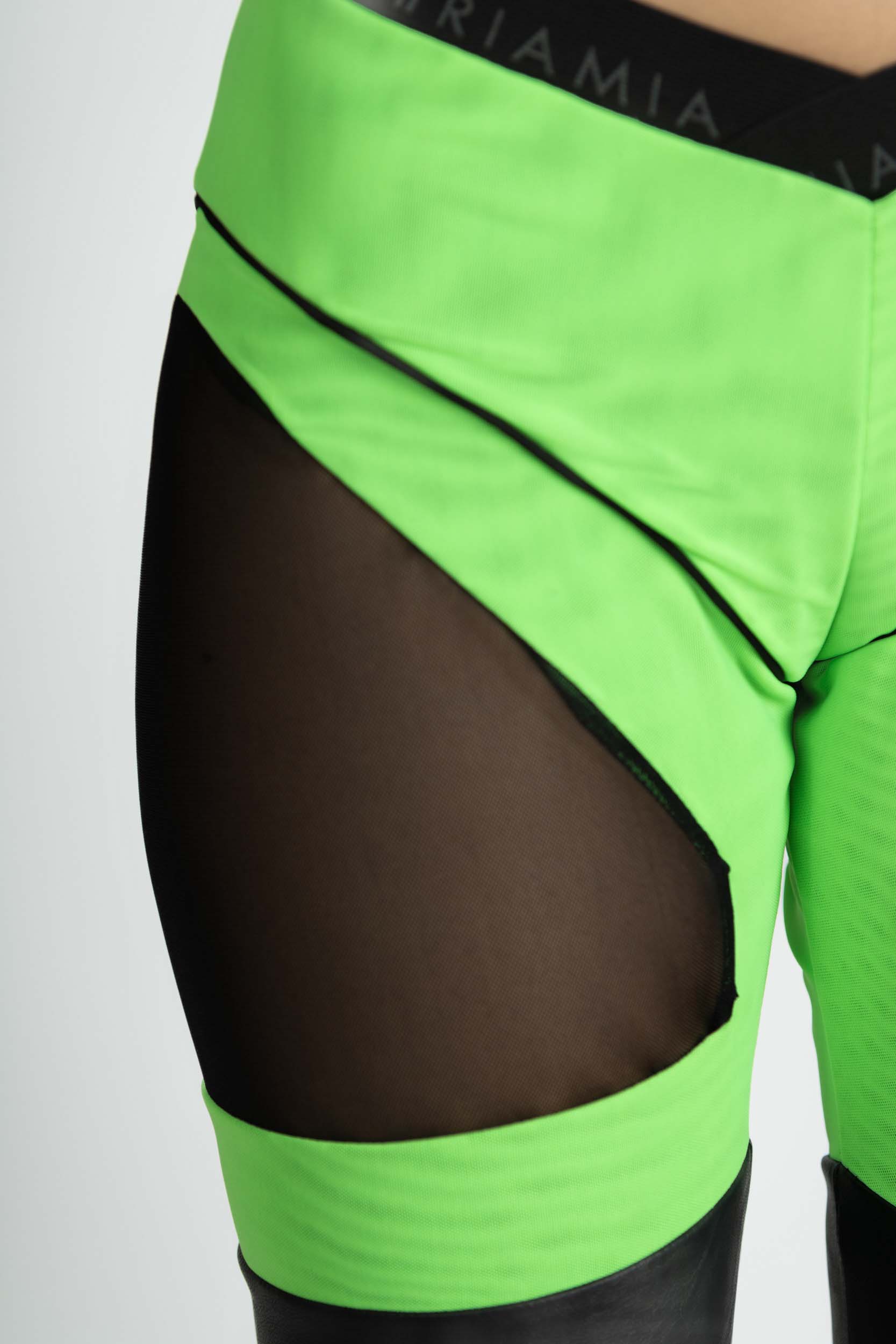 Leggings with combination of fabrics in black and neon green. Englared photo highlighting its details.