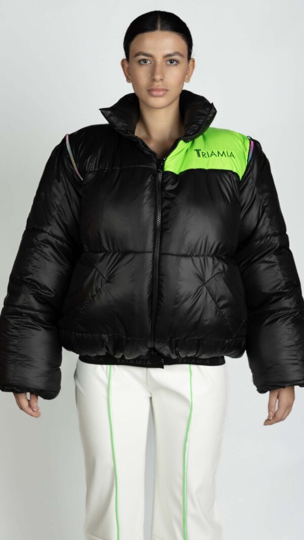 Oversized black and neon green puffer jacket with zipper and Triamia logo on one side. It also has detachable sleeves in order to transform it in a vest.