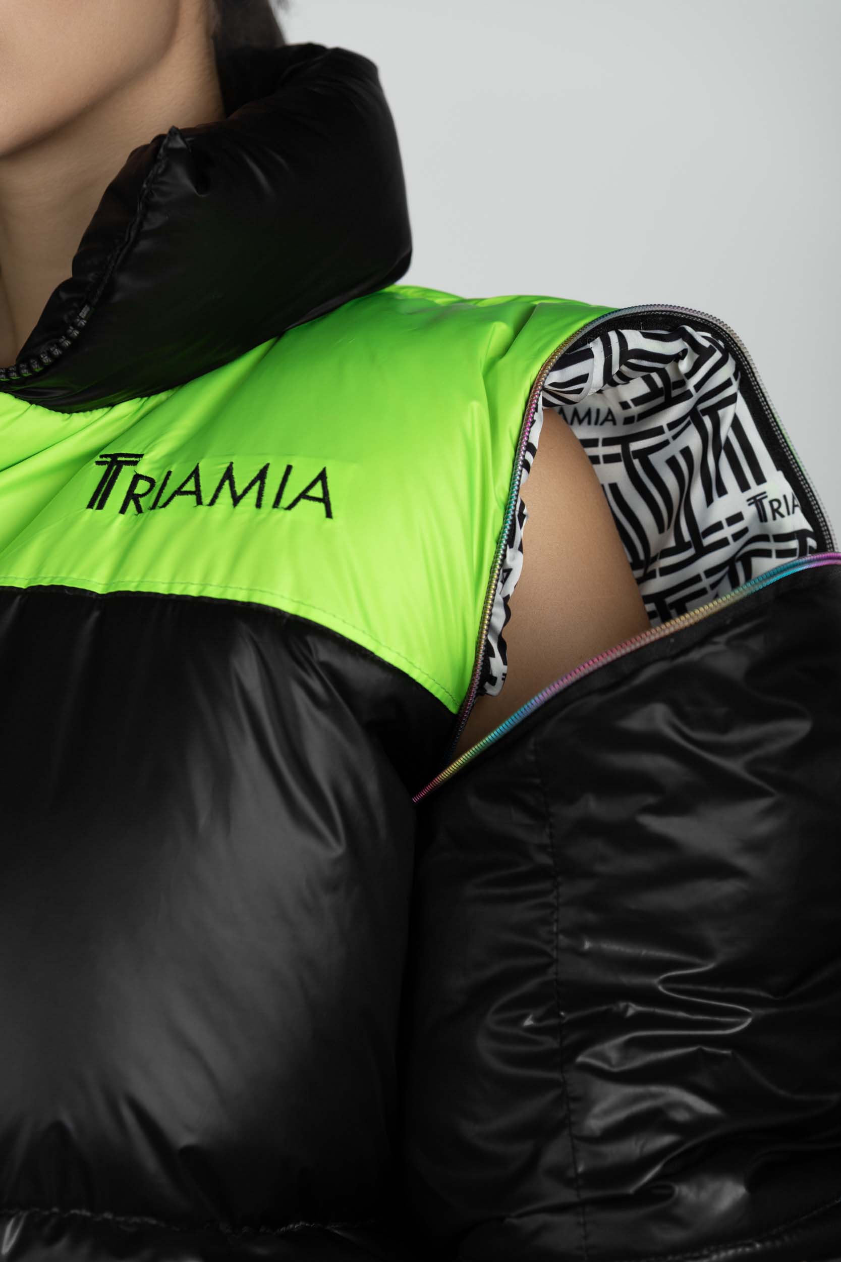 Oversized black and neon green puffer jacket's detachable sleeves details